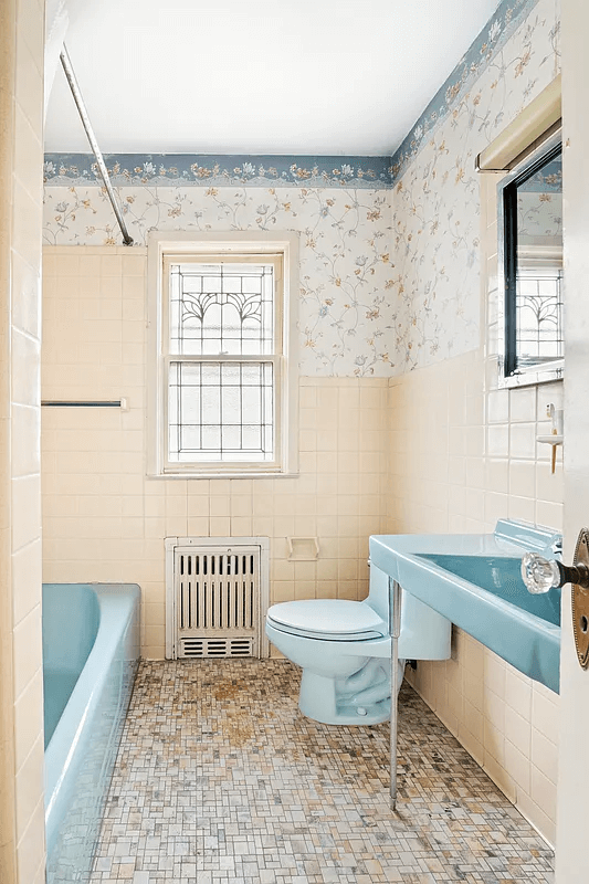 bathroom with blue fixtures and wallpaper