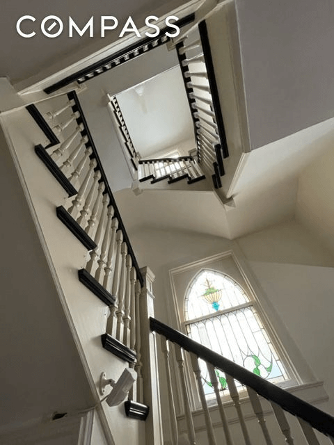 view looking up stair case with stained glass window