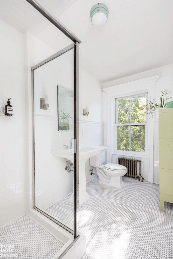 bathroom with shower and white fixtures