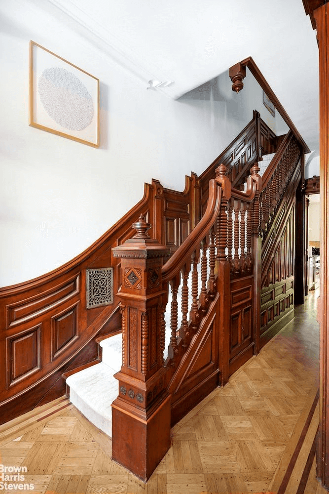main staircase with wainscoting and elaborate newel post