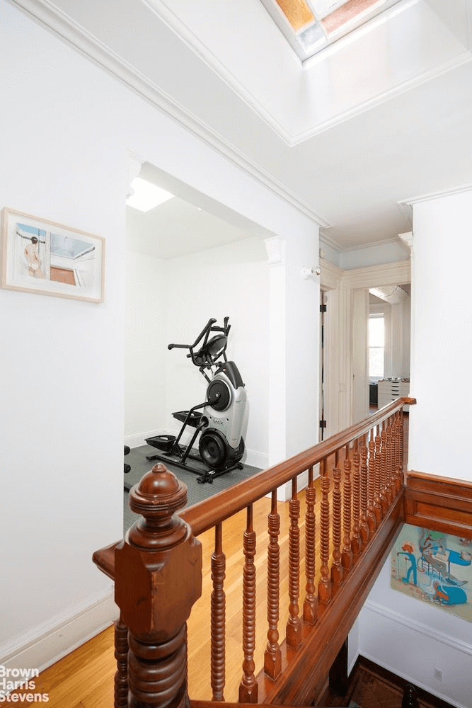 upstairs hall with a skylight and a wood railing