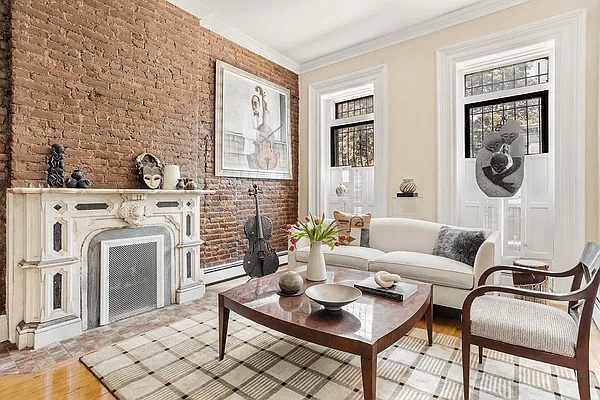 parlor with exposed brick wall and baseboard heat