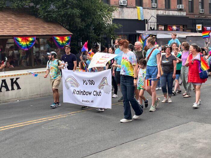 marchers holding a banner for the rainbow club of ps130