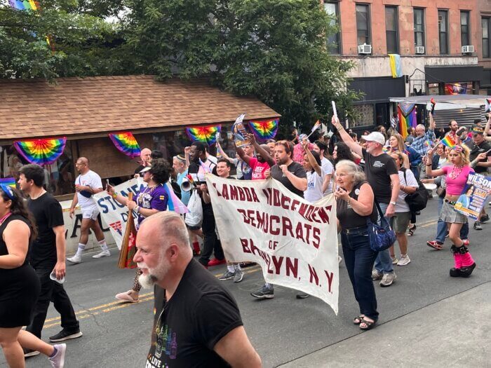 marchers hold a banner and wave to the crowd