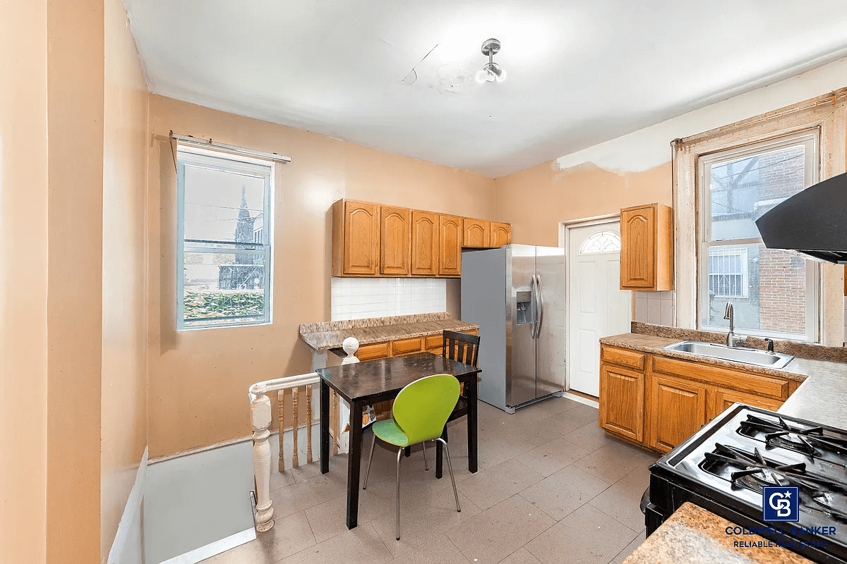 kitchen with wood cabinets and stair leading to basement