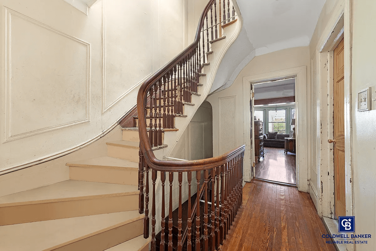 hallway with wall moldings and curved stair railing