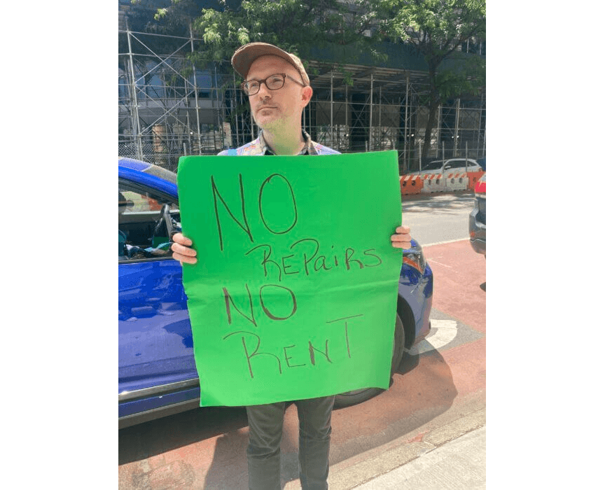 man holding a green protest sign