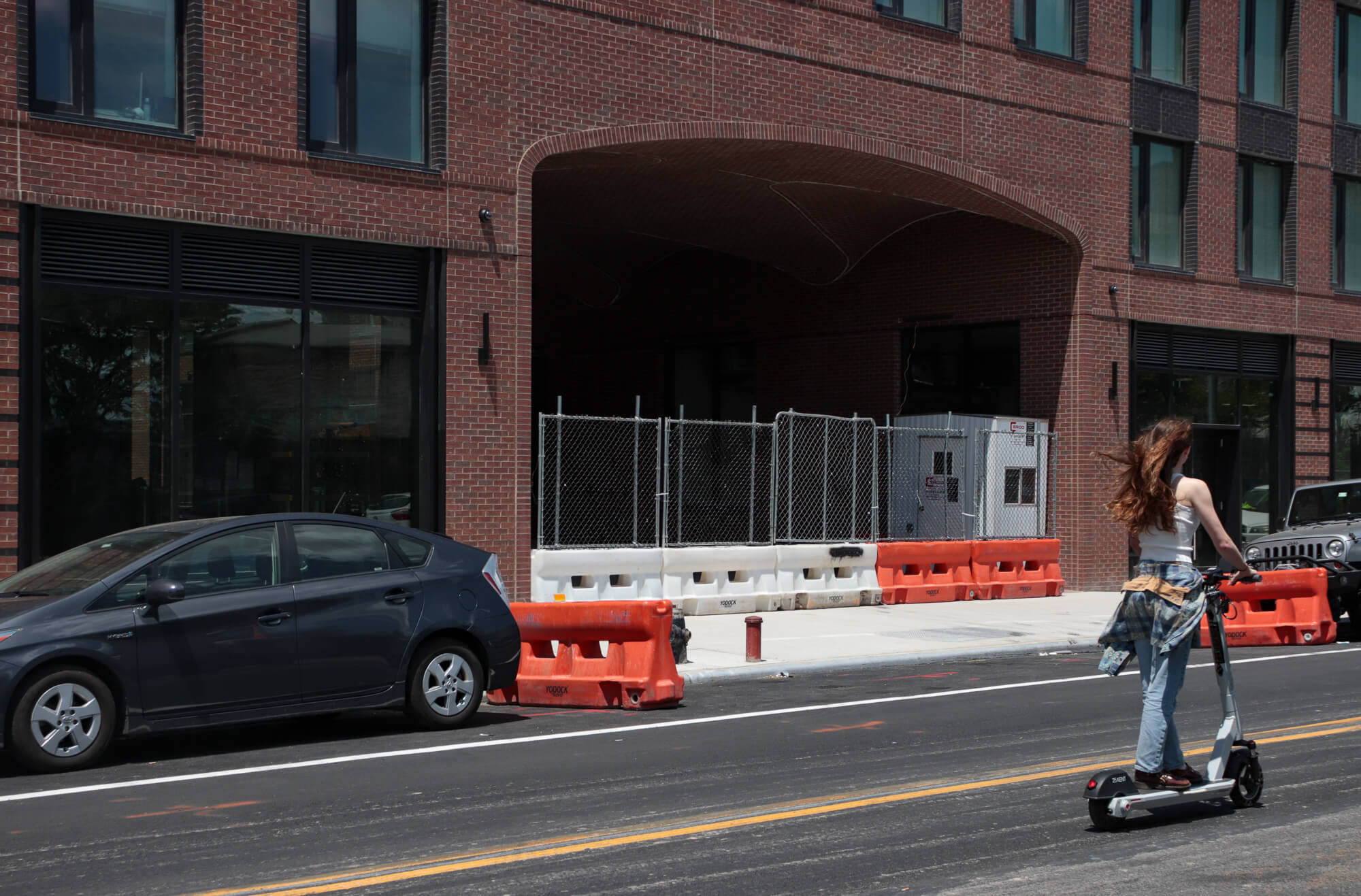 person on scooter riding past the entrance to 35 commercial street