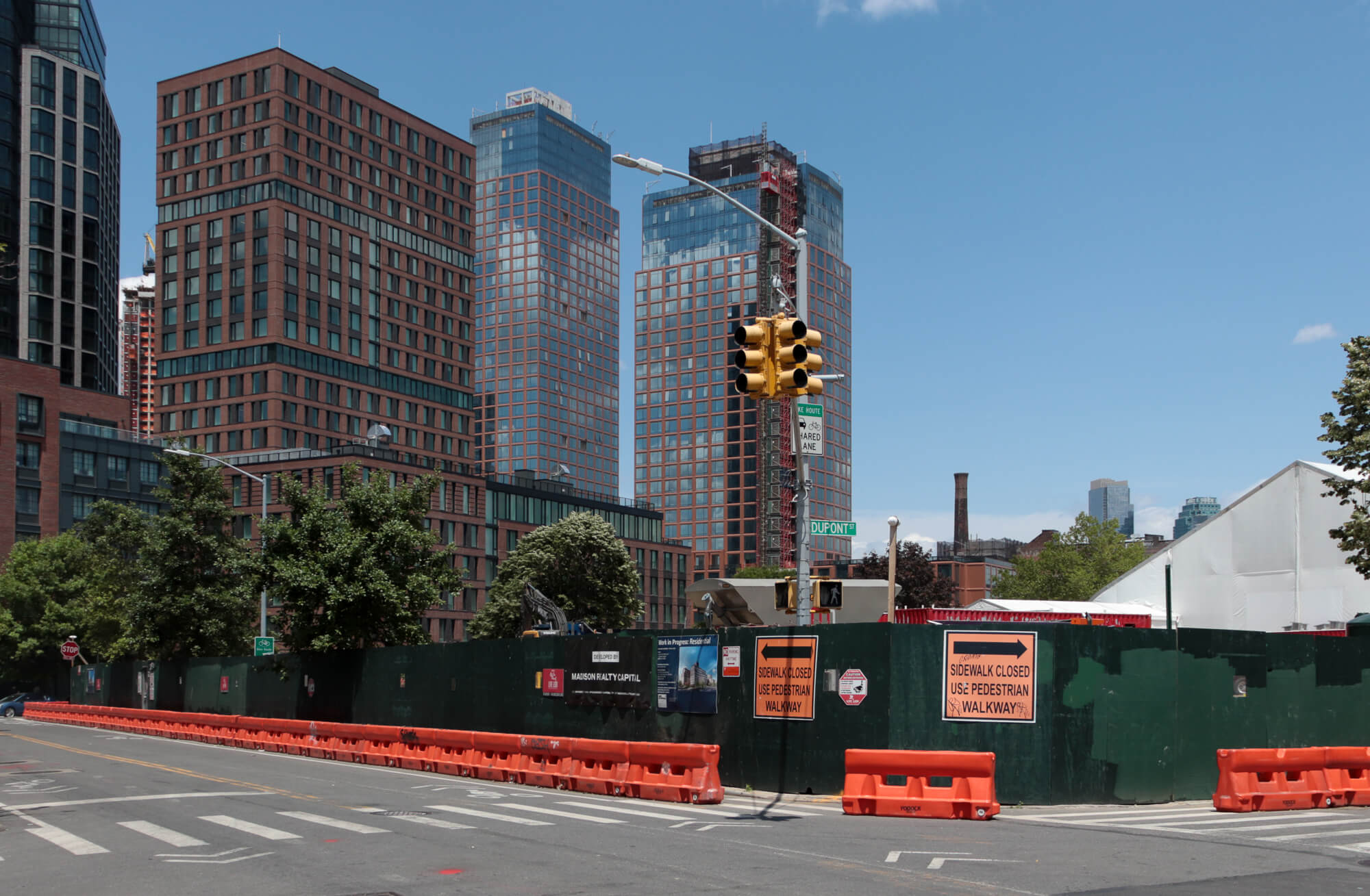 view of construction fence and new buildings in greenpoint