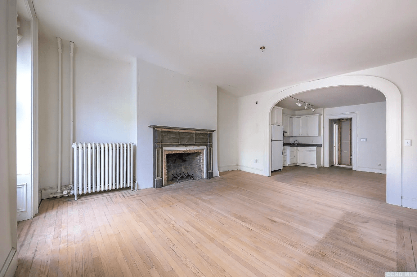 view from living room through arched opening to kitchen