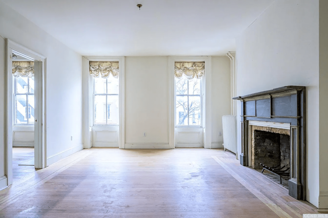 living room with mantel and two windows