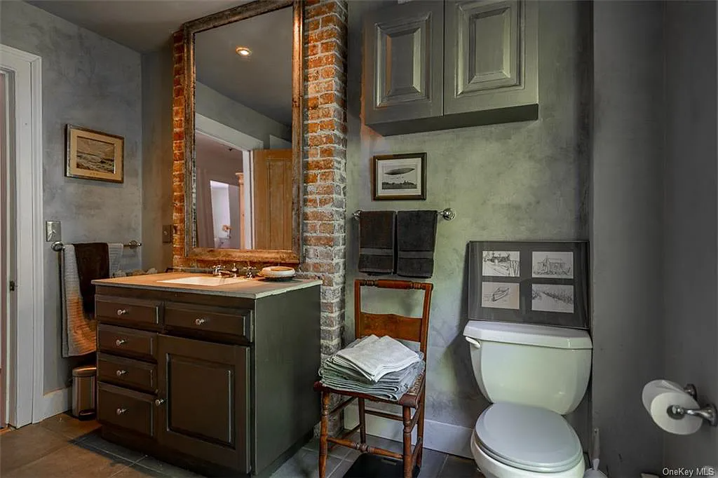 painted vanity and exposed brick chimney wall in the bathroom