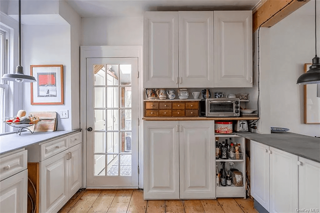 kitchen with white cabinets and glass door to studio