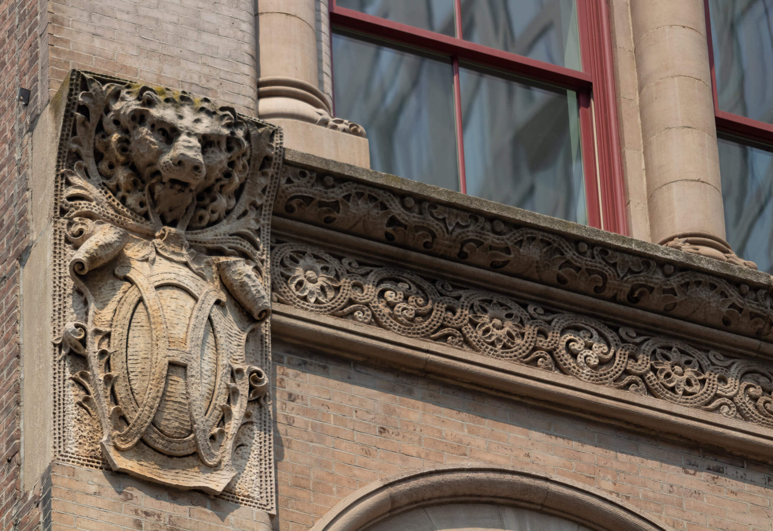 a lion head above the letter H are included in the ornamentation on the building