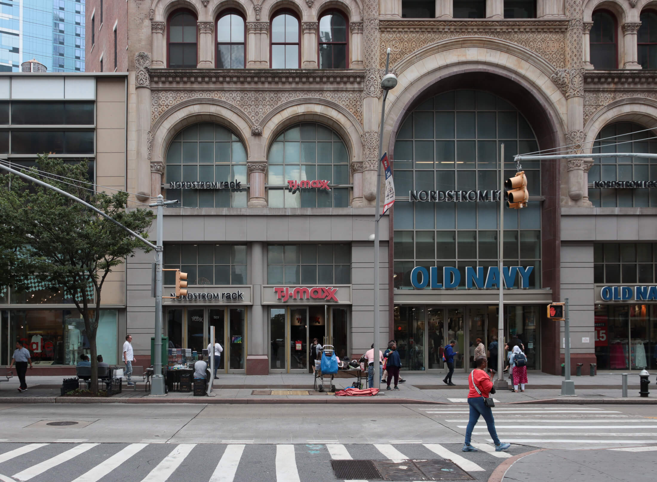 people walk by the storefronts along fulton street