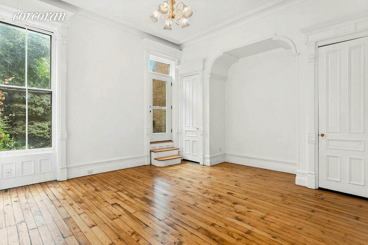 room with arched niche and steps up to door out to deck