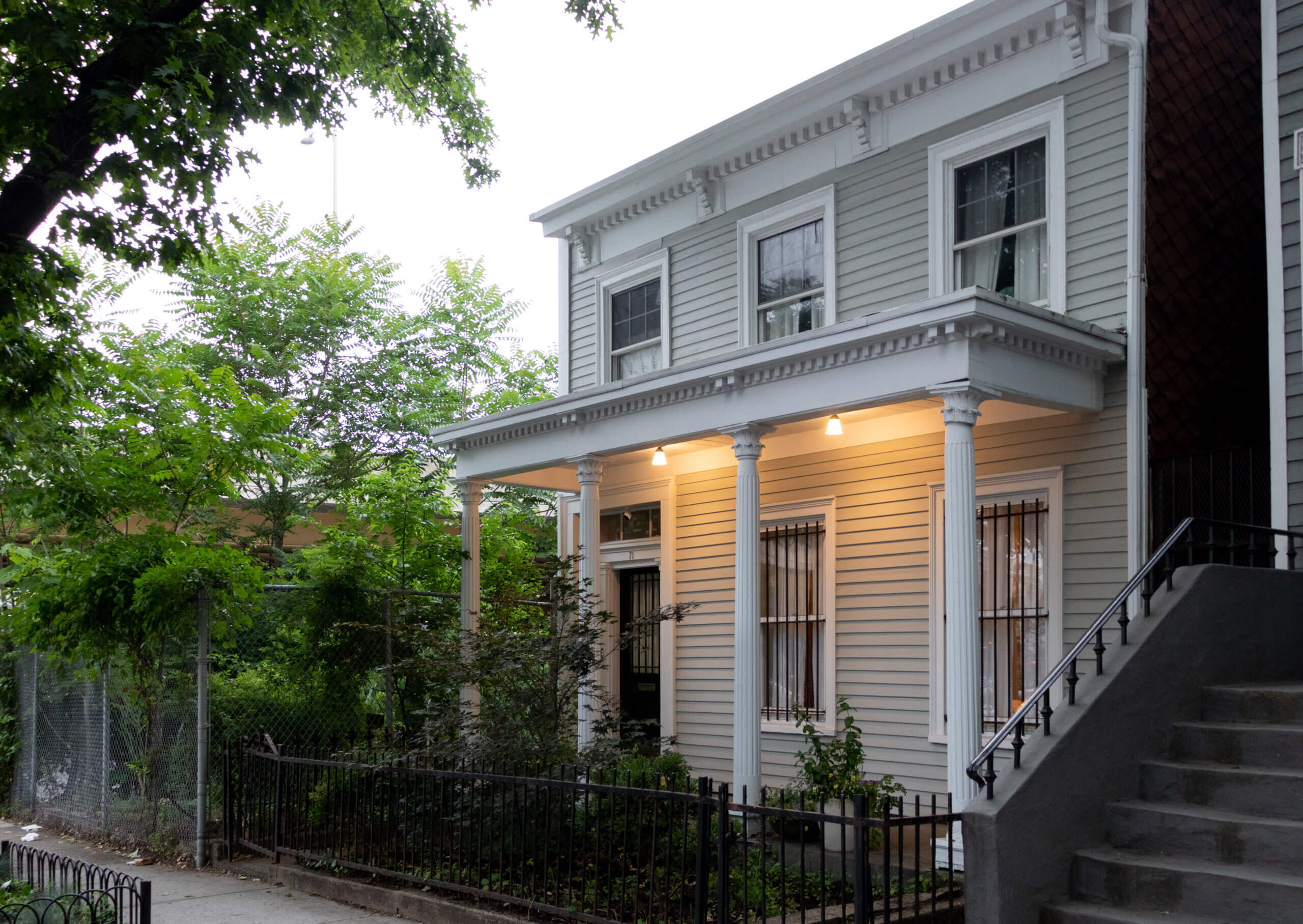 a wood frame house with a columned porch
