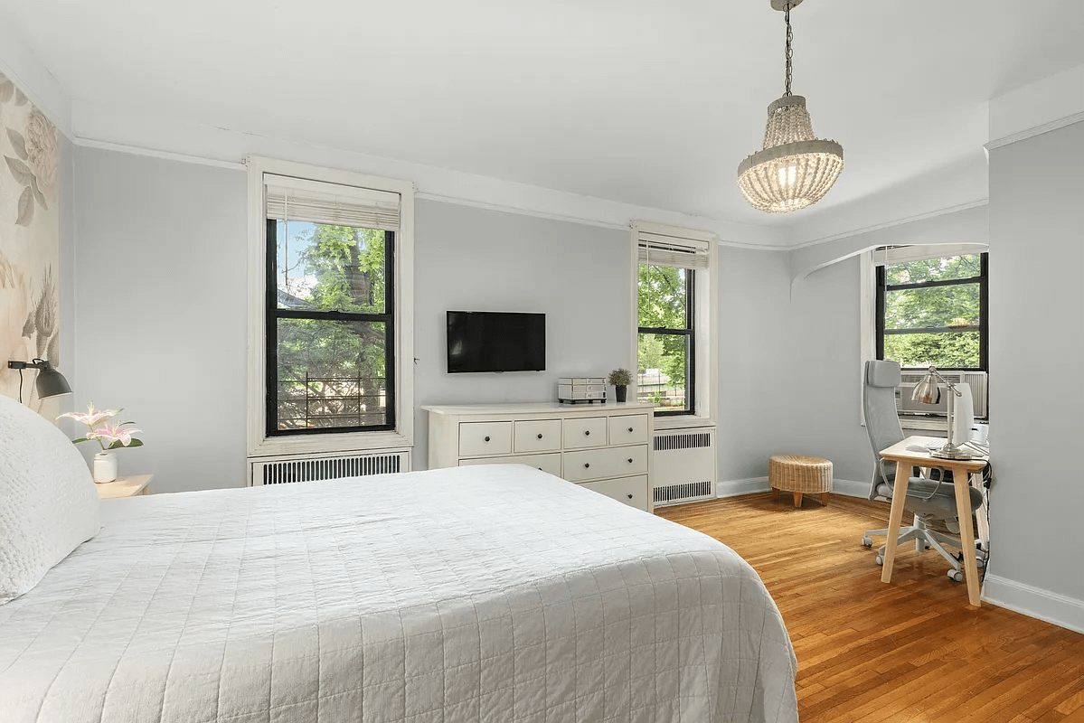 bedroom with three windows and wood floors