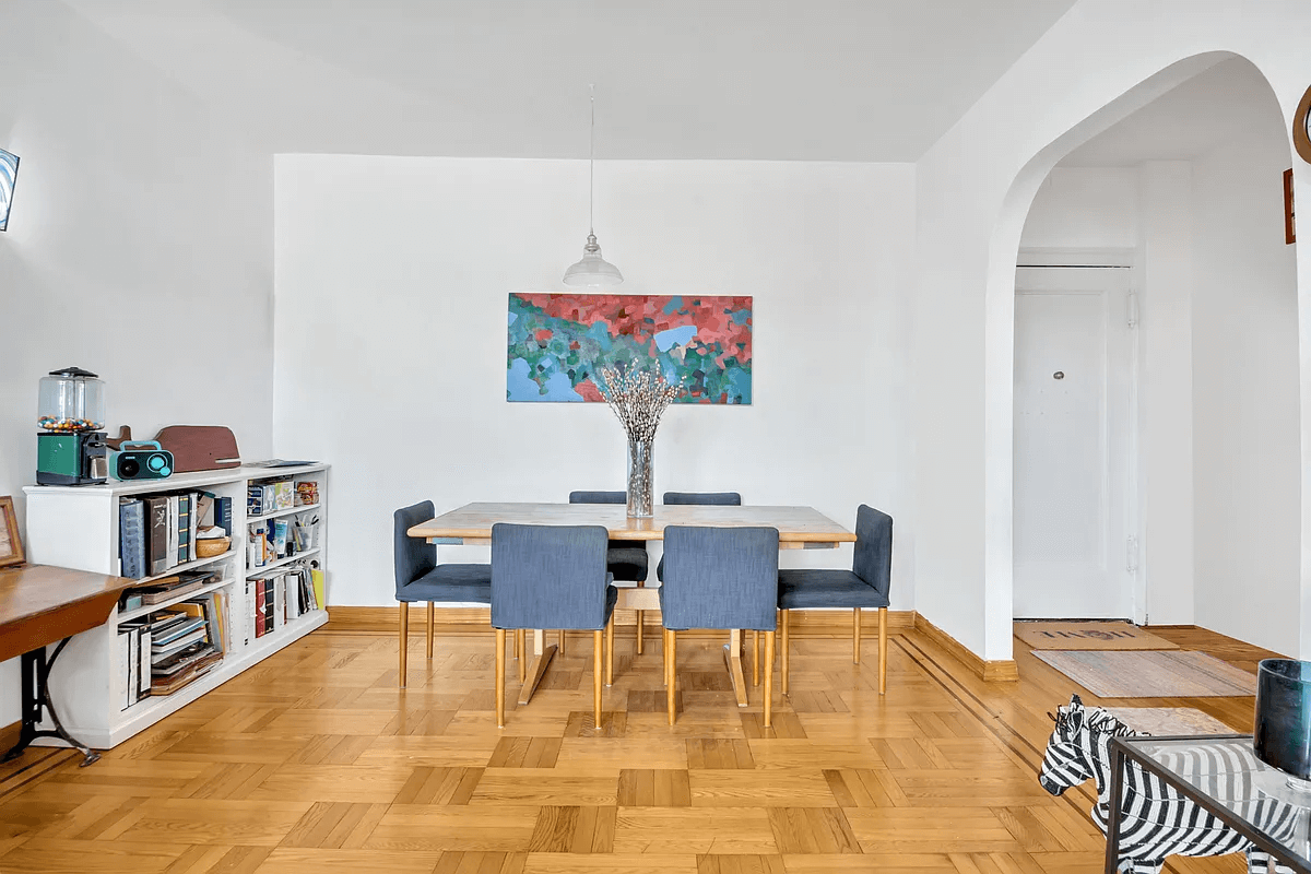 dining area with parquet floor and arched opening to foyer