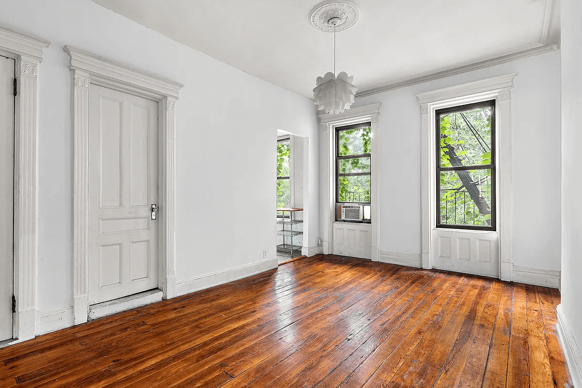 rear facing room with wood floors and doorway to kitchen