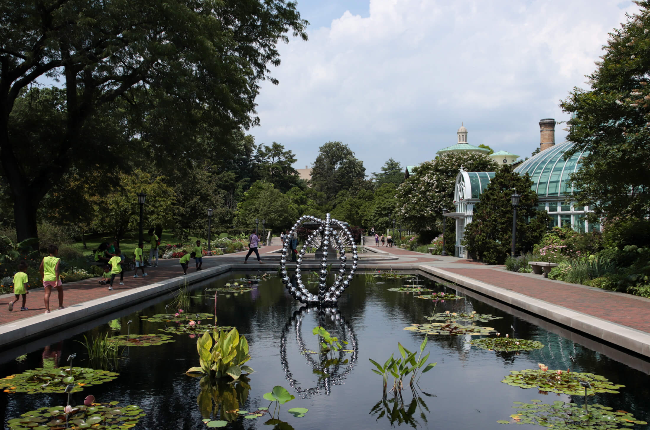 a view of an large silver bead flower sculpture installed in the lily pond
