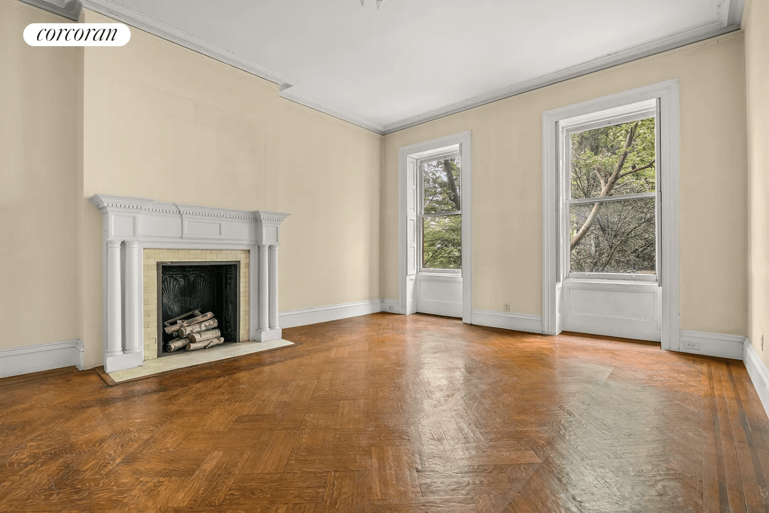 bedroom with crown molding, wood floors and a white painted mantel