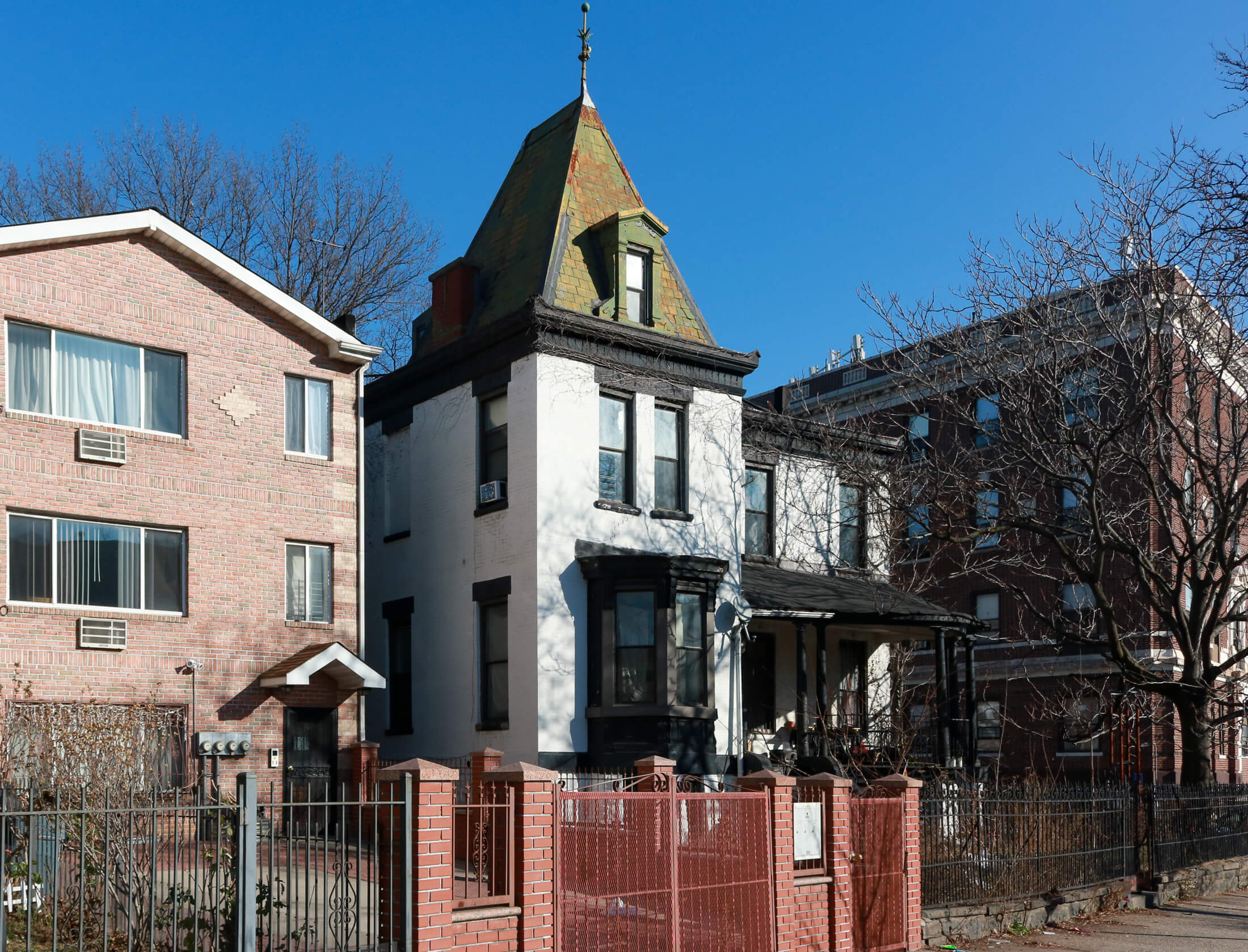 a white stucco house with tower and porch