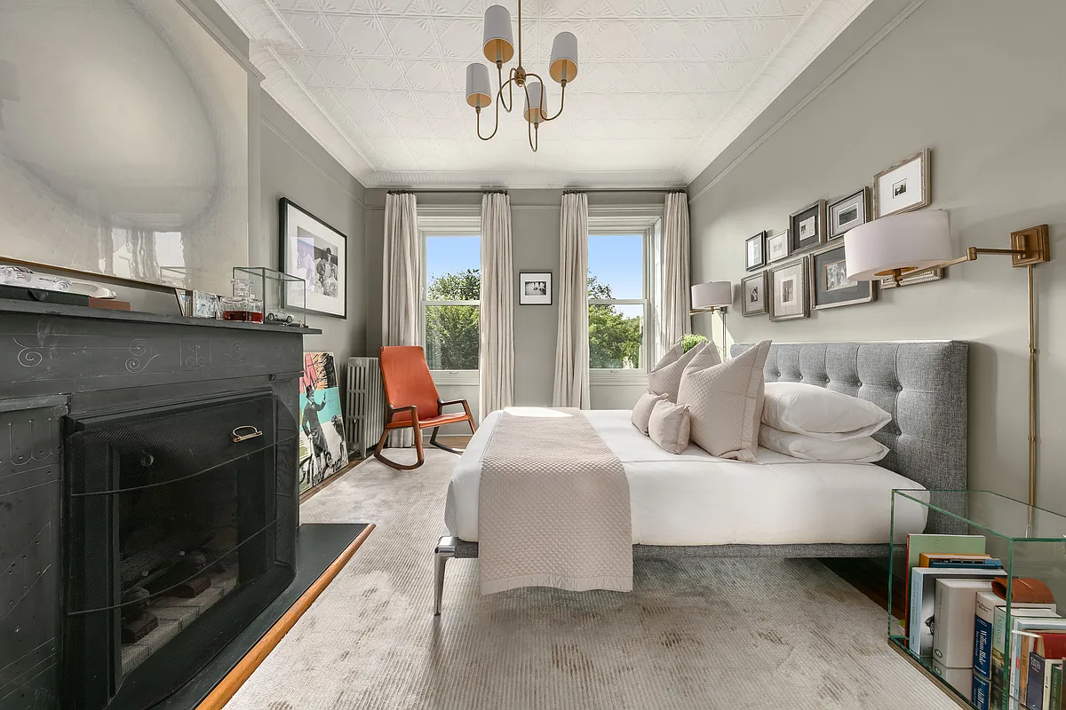 bedroom with tin ceiling and etched mantel