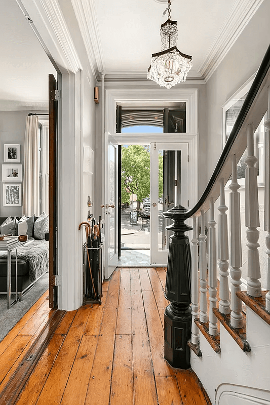 hallway with wood floors and original newel post