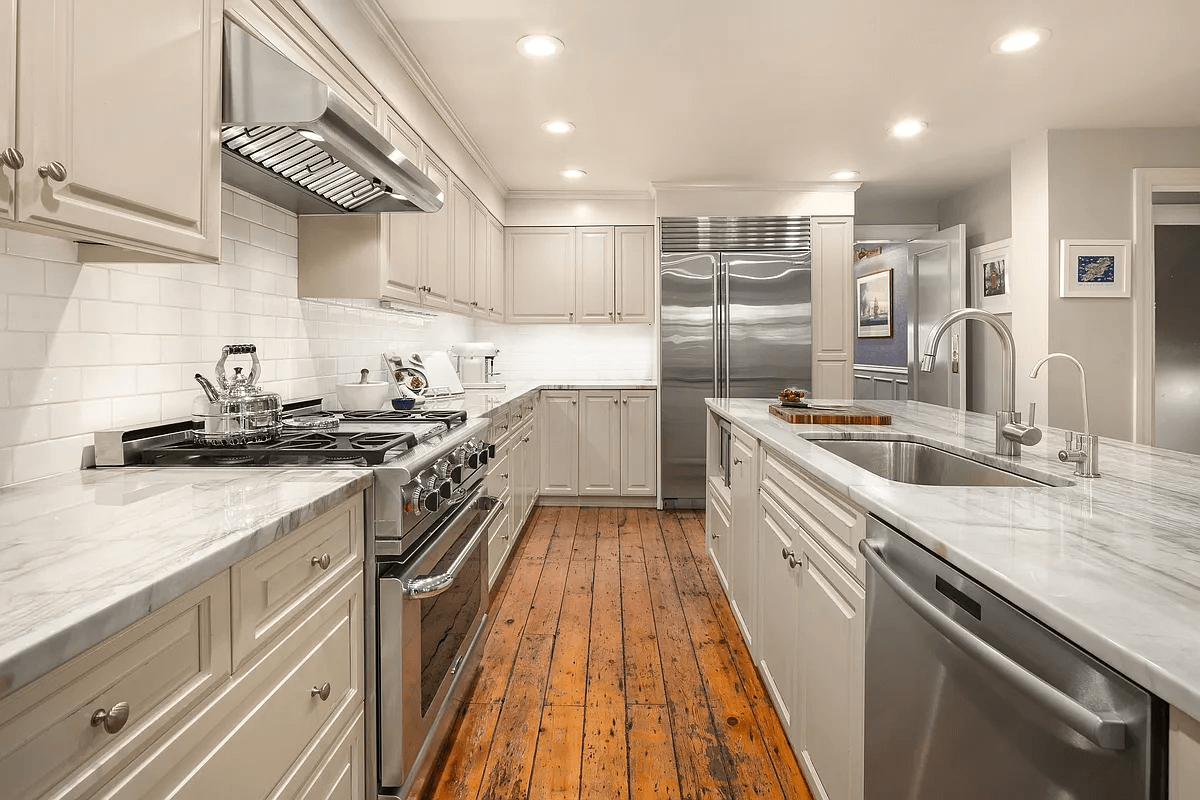 kitchen with wood floors, white cabinets and recessed lighting