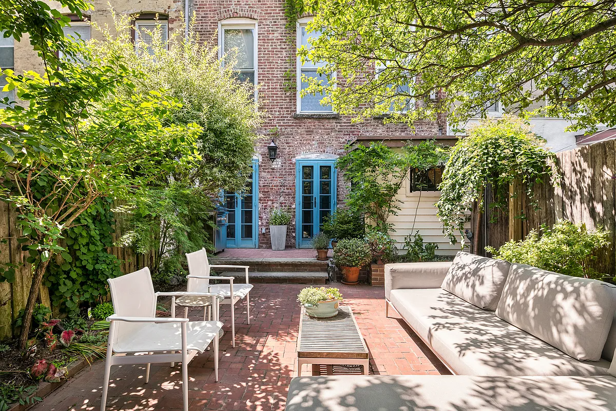 rear yard with brick patio and steps up to french doors