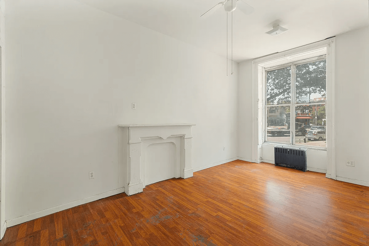 room with wood floors and a mantel painted white
