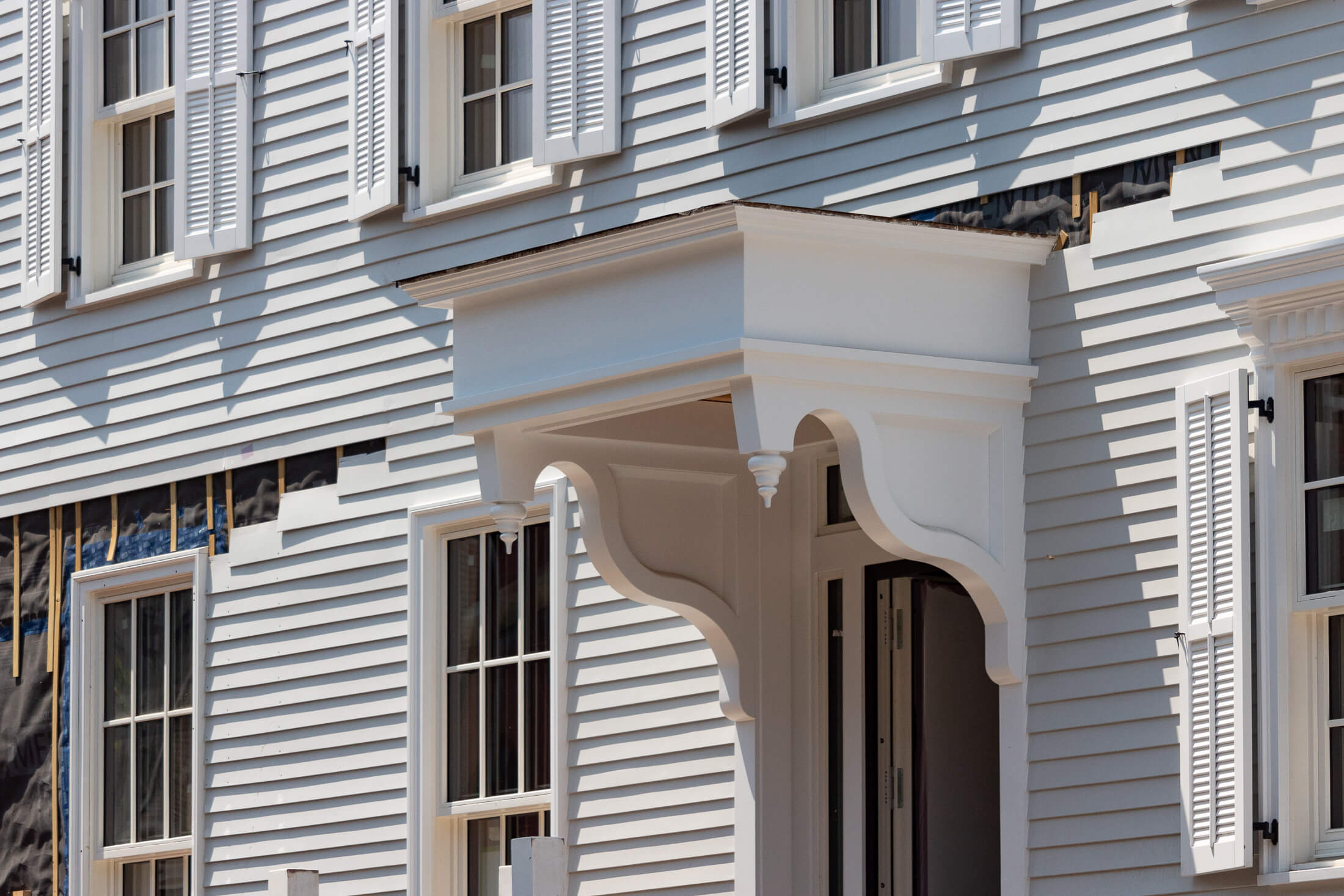 the doorhood and views of the not quite finished clapboard facade