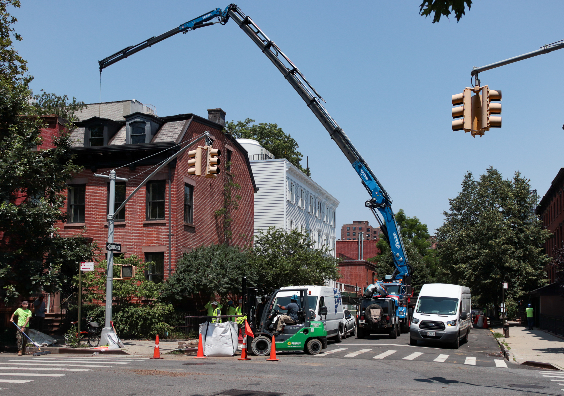 a large crane on waverly avenue with construction workers