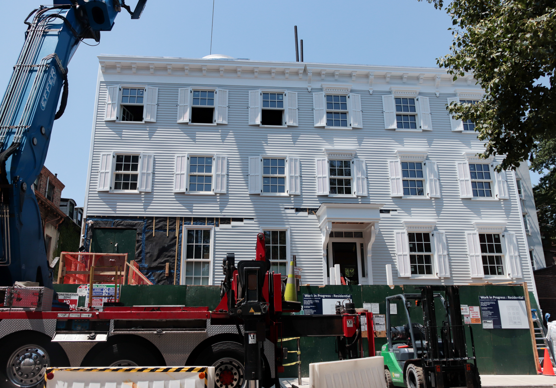 the front facades of both houses showing one door and some clapboard not yet in place