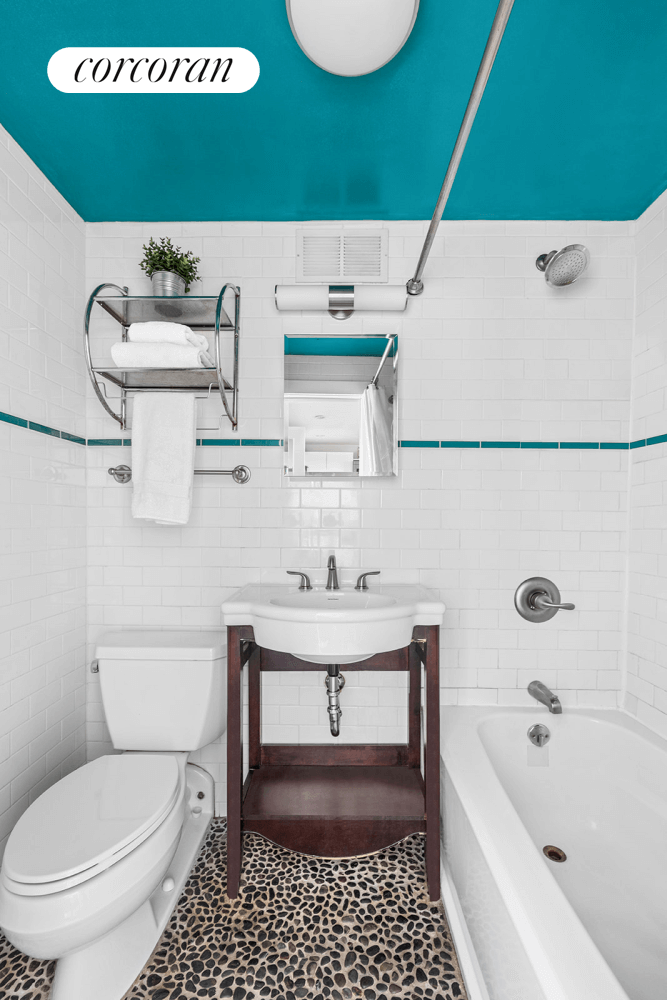 bathroom with white fixtures and white subway tile walls with turquoise border tile