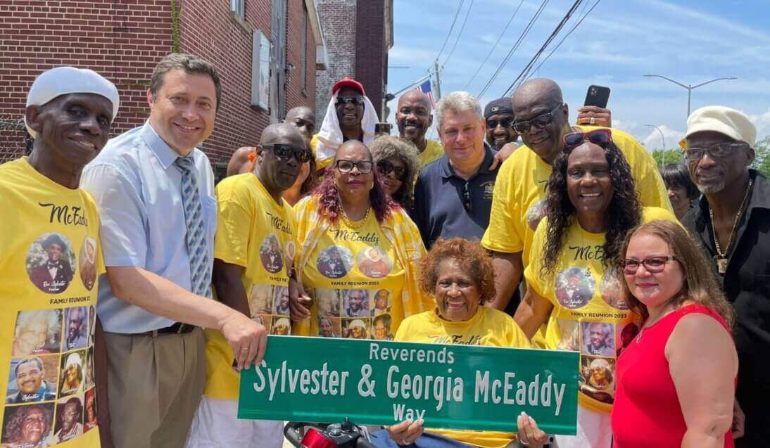 co-naming streets - people posing around a street sign