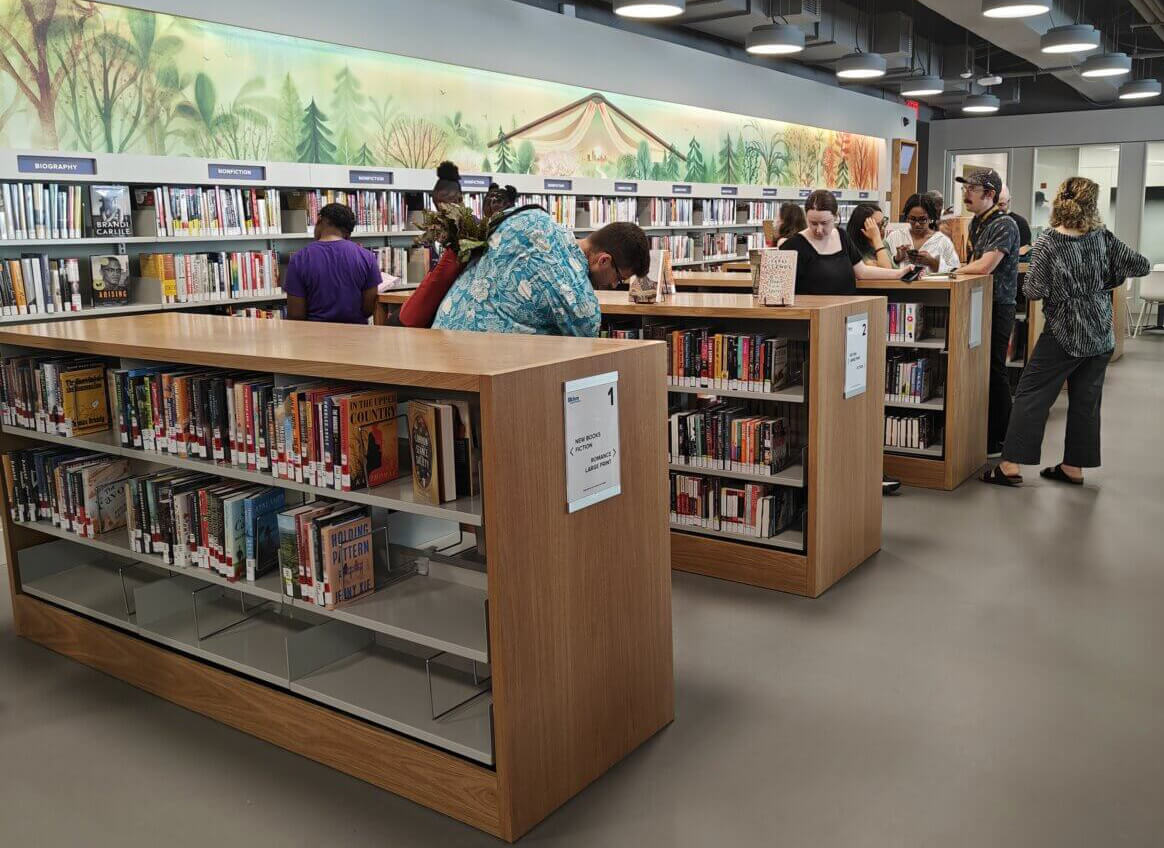 a view inside the brower park library with people looking at books on the shelves