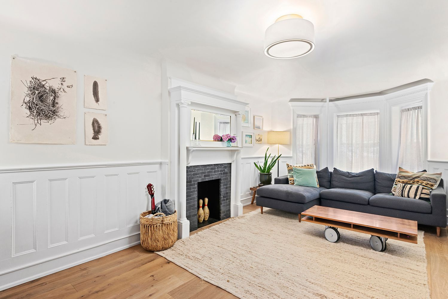 living room with wainscoting and a white painted mantel