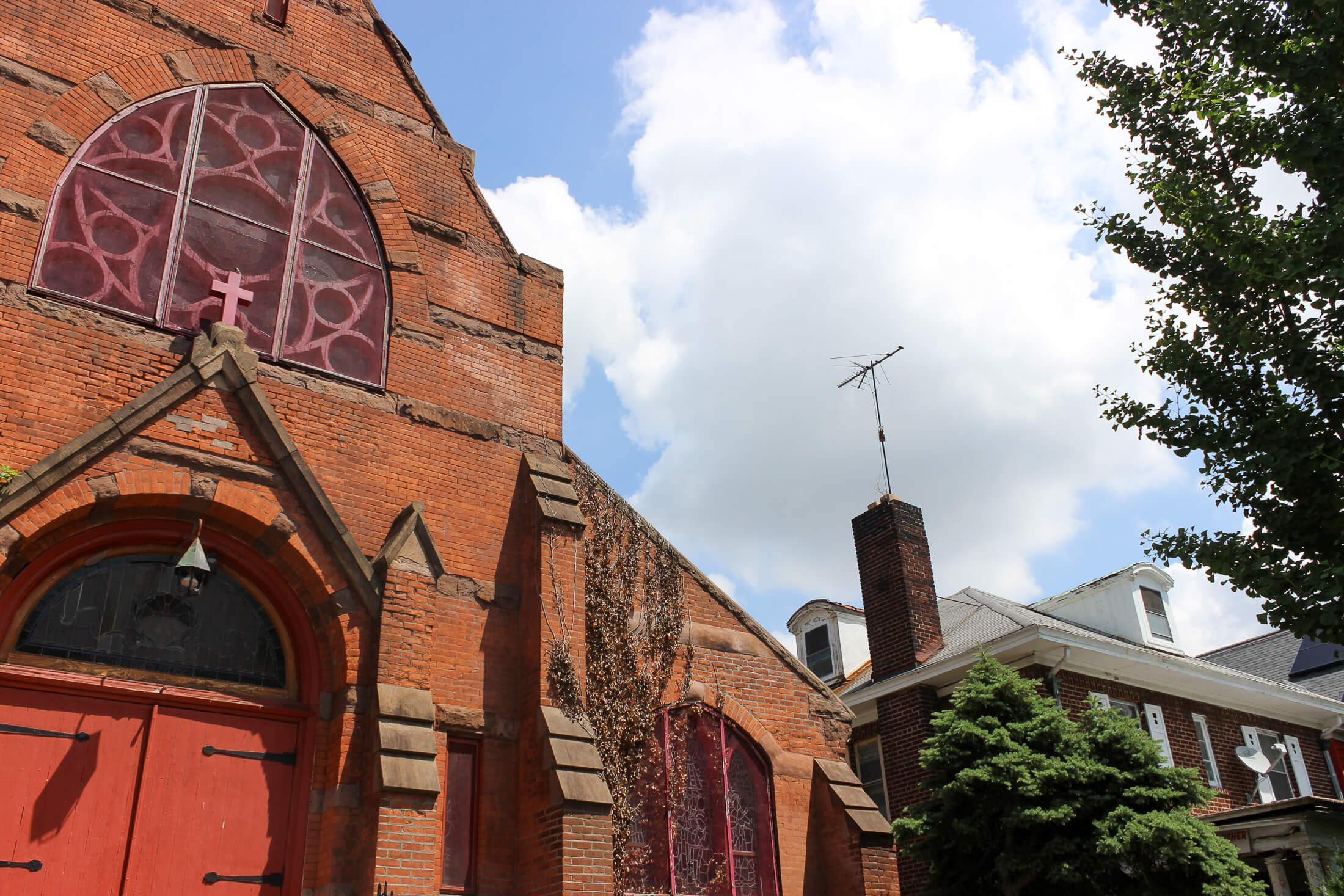 a red brick church and a house with dormers