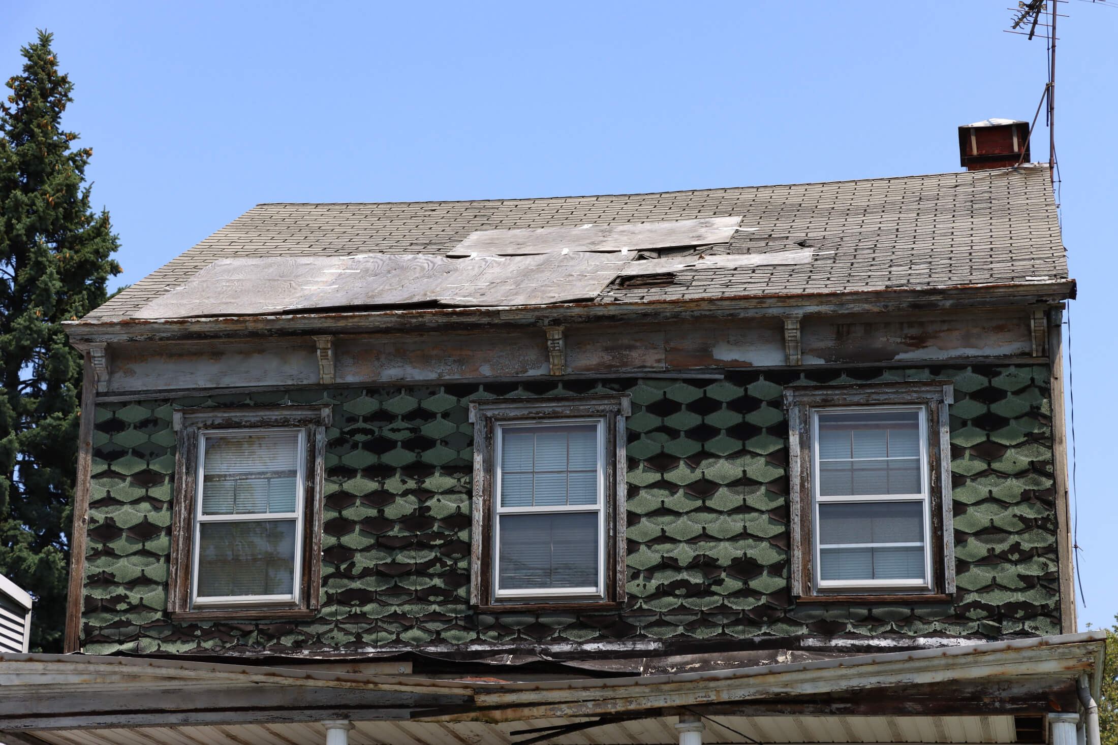 a view of the roof which shows some patching and holes