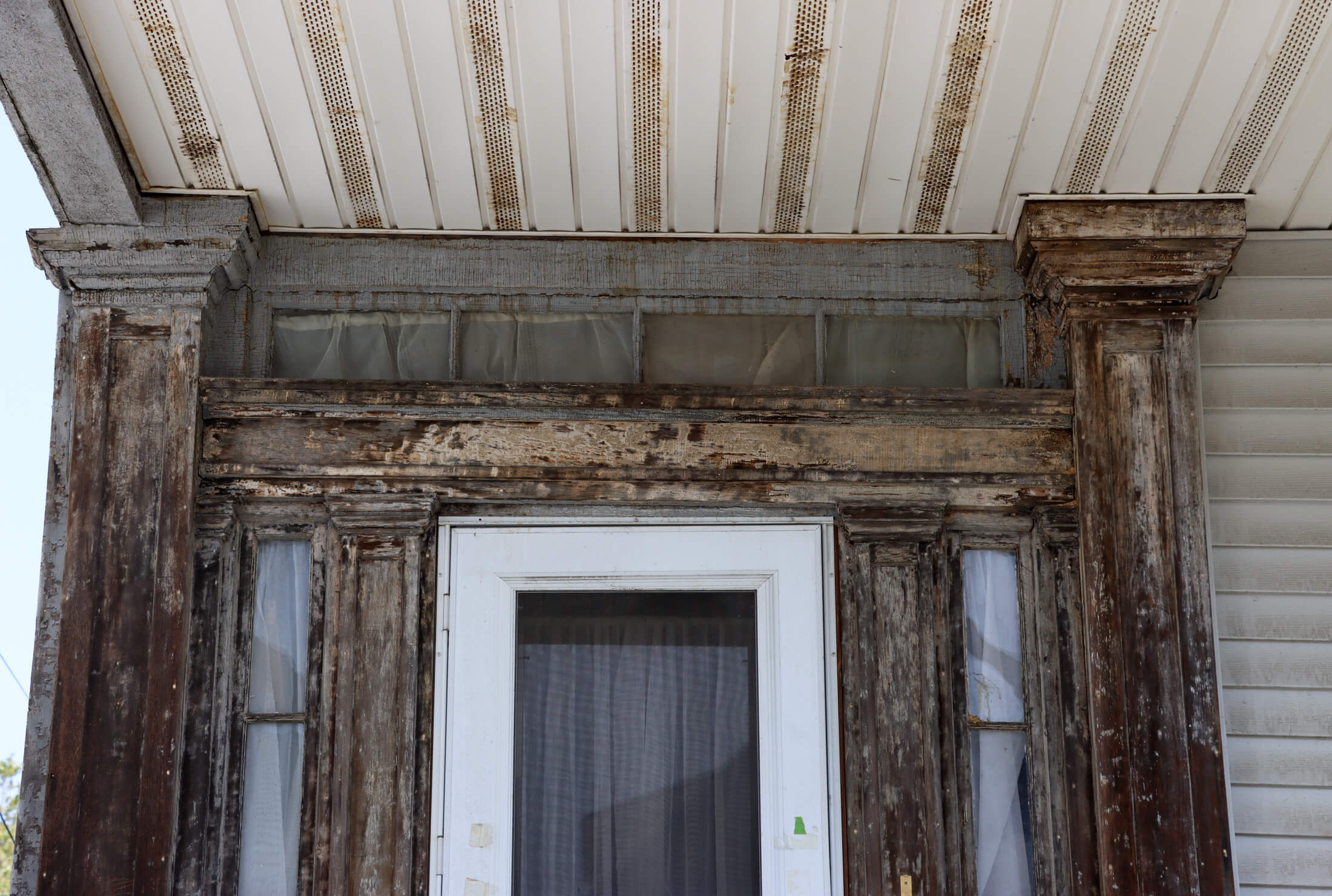 a closeup of the greek revival wood door surround with pilasters