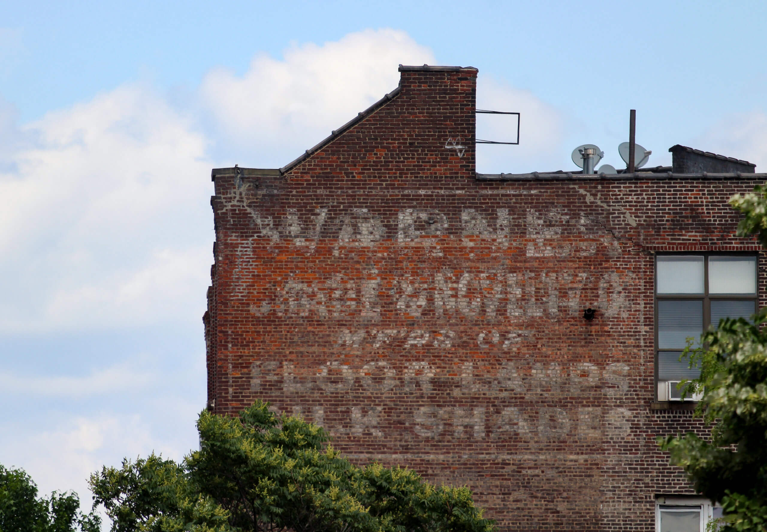 a ghost sign for window shades on the side of a building