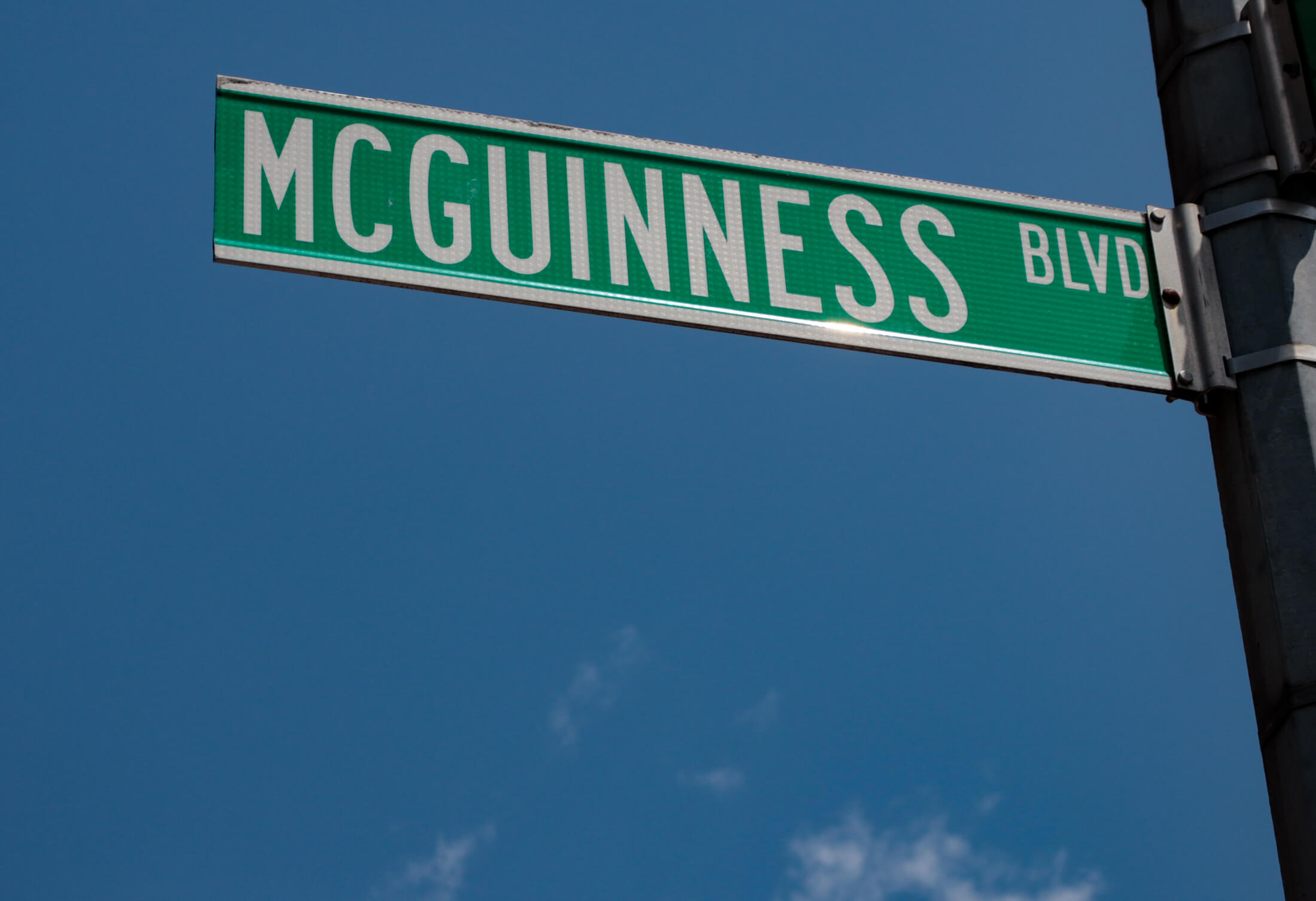 mcguinness boulevard street sign against a blue sky