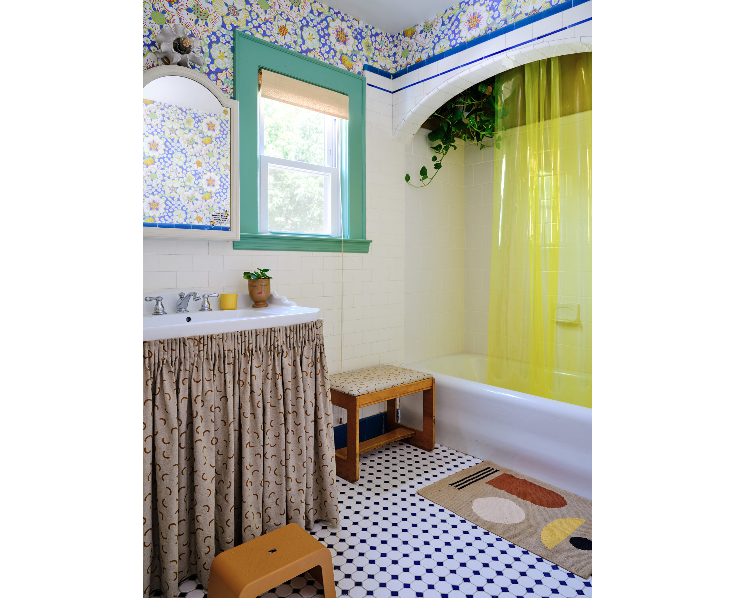 a colorful bathroom with floral wallpaper and a yellow shower curtain