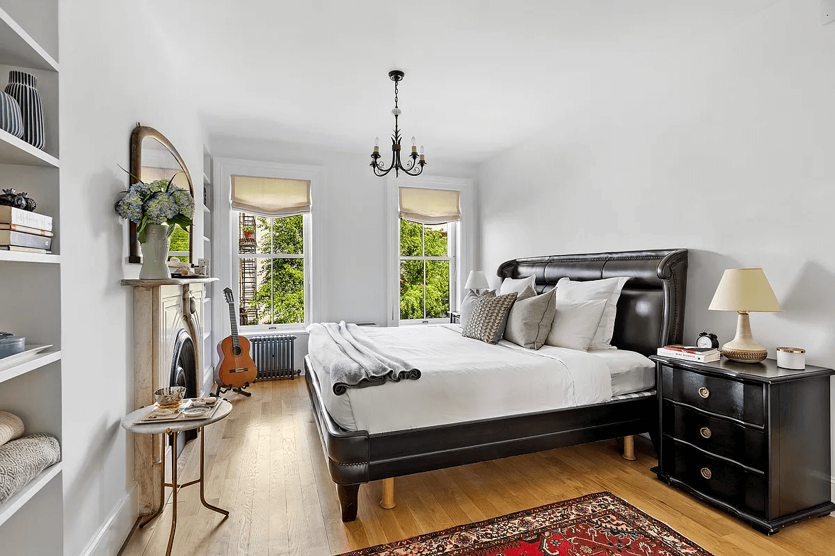 a bedroom with built-in shelves and two windows