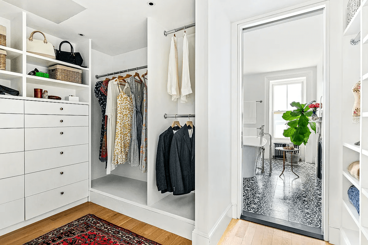 walk-in closet with built-in drawers and divided hanging space off the bathroom