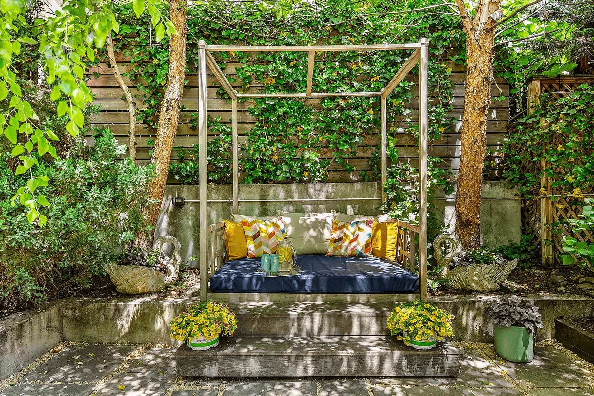 a seating area at the rear of the garden with trees on either side