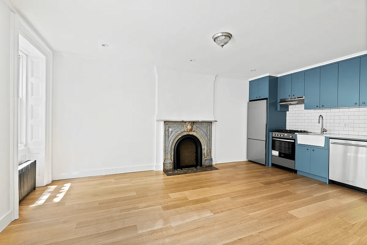 the kitchen in the garden apartment with a white subway tile backsplash and blue cabinets