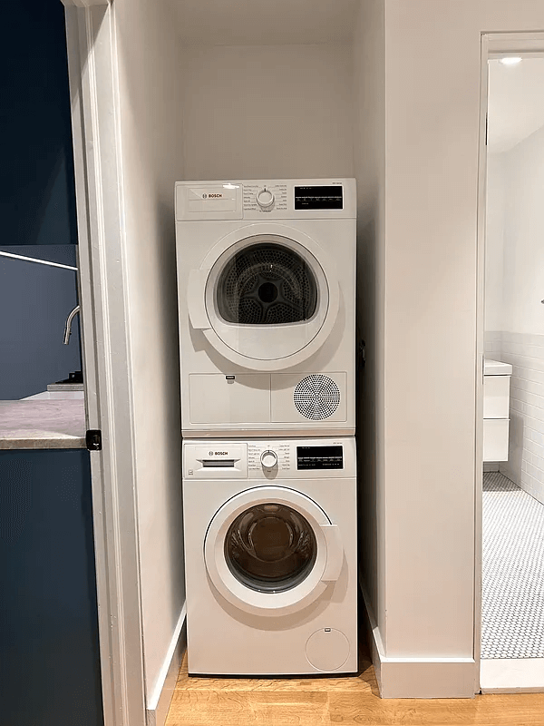stacked washer/dryer in a niche next to the bathroom
